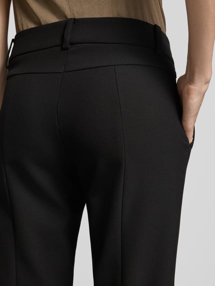 Frauenmodel trägt Slim Fit Hose aus Webware mit Bügelfalten Modell 'SARAH' von CAMBIO, schwarze Farbe, glatte Textur, Nahaufnahme Rückansicht, Damen Schmale Hose von CAMBIO.