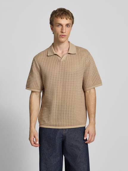 Męski model nosi Regular Fit Poloshirt mit V-Ausschnitt von Jack & Jones z czystej bawełny, beżowy, faktura dzianinowa, krój regular fit, długość tyłu w rozmiarze M: 67 cm, całkowity widok z przodu.