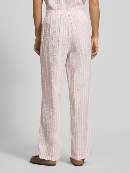 Frauenmodel trägt Straight Leg Hose aus reiner Baumwolle Modell 'TINNA' von Pieces mit Allover-Muster, Crinkle-Struktur, Ganzkörperansicht Rückansicht.