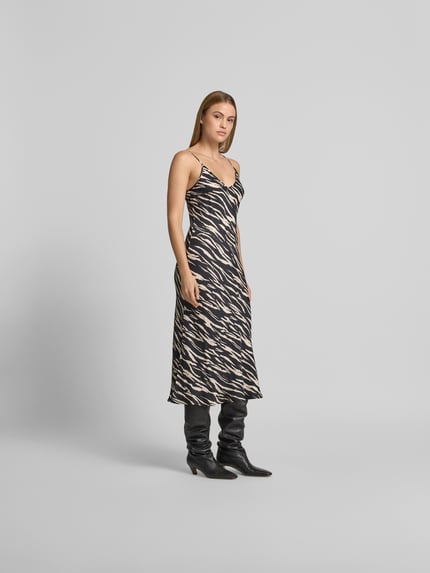 Kobiece modelka nosi sukienkę midi z cienkimi ramiączkami, dekoltem w serek, długość midi, czarno-beżowy wzór, sukienka midi aus reiner wiskoza od Lala Berlin, krój slim fit, szerokość w rozmiarze S: klatki piersiowej 40 cm, talii 35 cm, całkowita długość 110 cm, widok całej sylwetki z przodu.