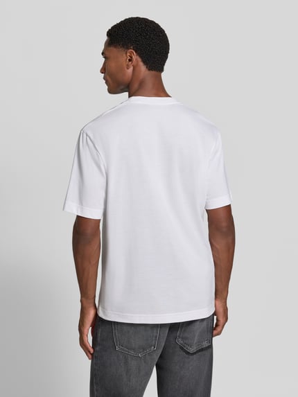 Männermodel trägt Regular Fit T-Shirt aus reiner Baumwolle von Lacoste in Weiß, einfache Struktur und glatte Oberfläche, Ganzkörperansicht Rückansicht.