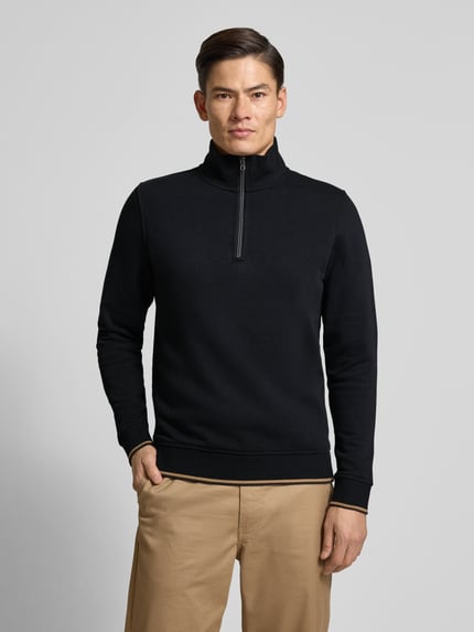 Męski model nosi Regular Fit troyer z mieszanki bawełny od Christian Berg Men, kołnierz zapinany, elastyczne wykończenia, długość tyłu 68 cm, rękawy 66 cm, widok z przodu na całą sylwetkę.