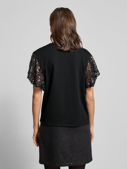 Frauenmodel trägt T-Shirt mit geripptem Rundhalsausschnitt Modell 'WINGS' von FREE/QUENT, schwarz, Paillettenbesatz, Rückenansicht Ganzkörperansicht.