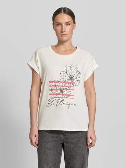Frauenmodel trägt T-Shirt mit fixiertem Ärmelaufschlag Modell 'RINA' von Soyaconcept, Baumwoll-Mix, beiger Stoff, Print, Ganzkörperansicht von vorne.