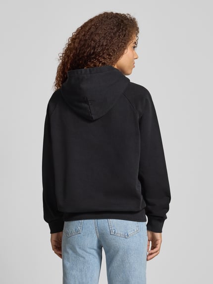Frauenmodel trägt Hoodie mit Label-Stitching von Pegador aus schwarzem Baumwoll-Mix mit Kapuze, Lockerer-Schnitt, Känguru-Tasche, Gerippte-Abschlüsse, Ganzkörperansicht Rückansicht.