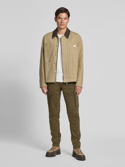 Männermodel trägt Cargohose mit Pattentaschen Modell 'EXPEDIZOR' von PME Legend in Grün, Skinny Fit, Ganzkörperansicht von vorne.