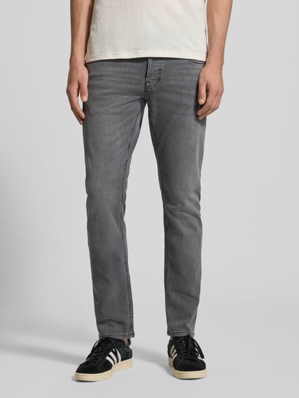 Męski model trägt Straight Fit Jeansy im 5-Pocket-Design Modell 'GLENN' von JACK & JONES, mieszanka bawełny z dodatkiem streczu, prosty krój, zapięcie na guzik i zamek błyskawiczny, szerokość w rozmiarze 32/32: 41 cm, długość wewnętrzna nogawki: 77 cm, szary kolor, gładka faktura, całkowity widok z przodu.