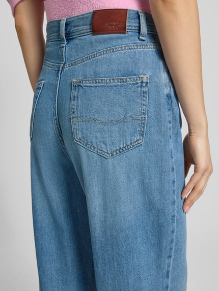 Frauenmodel trägt Tapered Fit Jeans aus Baumwoll-Mix Modell 'ADDISON' von Pepe Jeans, hellblaue Denim-Optik, Label Patch, Nahaufnahme Rückansicht.