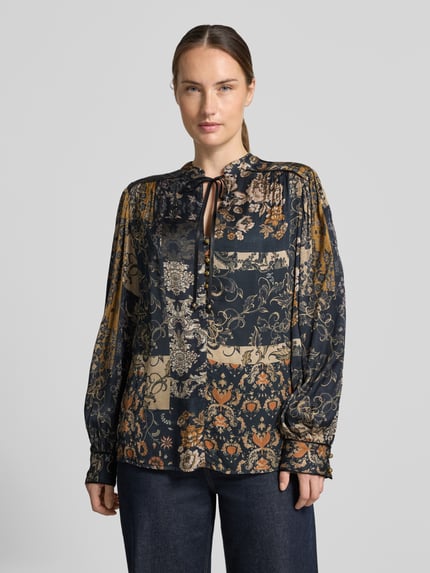 Frauenmodel trägt Tunika-Bluse aus reiner Viskose von Liu Jo White, dunkle Muster, gerade Passform, Schnürung, Nahaufnahme Oberkörper.