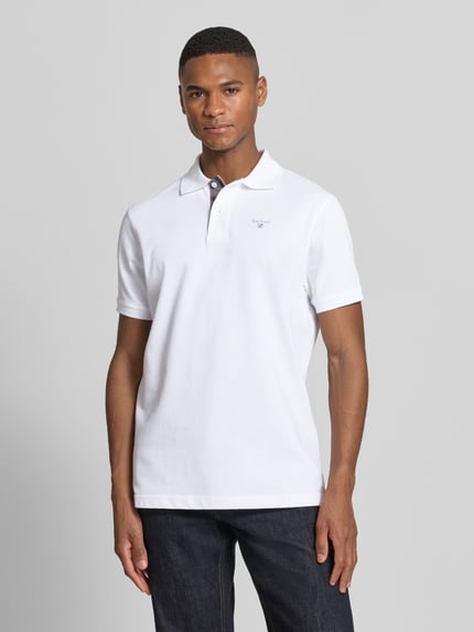 Męski model nosi Regular Fit Poloshirt aus reiner Baumwolle od Barbour, biały kolor, krój regular fit, pikowana bawełna, widok z przodu, ujęcie całej sylwetki.
