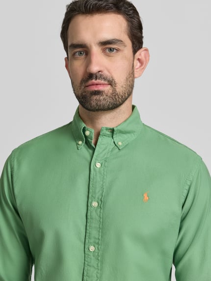 Männermodel trägt Freizeithemd mit Knopfleiste von Polo Ralph Lauren aus reiner Baumwolle, Regular-Fit, Button-Down-Kragen, Label-Stitching, Nahaufnahme Oberkörper.