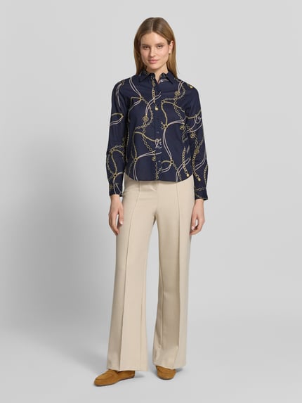 Frauenmodel trägt Regular Fit Bluse im Allover-Look von Gant, dunkelblau mit beigem Print, reine Baumwolle, Knopfleiste, Ganzkörperansicht von vorne.
