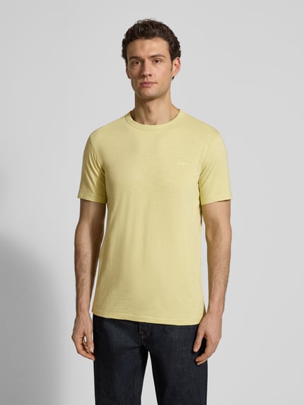 Męski model nosi Regular Fit T-Shirt aus strukturierter Baumwolle Modell 'TEGOOD' od BOSS Orange, jednokolorowy, krótkie rękawy, okrągły dekolt, czysta bawełna, delikatny nadruk z logo, widok całej sylwetki z przodu.