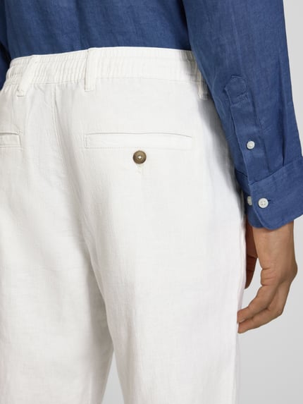 Männermodel trägt Loose Fit Leinenhose mit Tunnelzug Modell 'BRODY' von Selected Femme, Bio-Baumwoll-Leinen-Mix, Detailaufnahme Rückansicht.