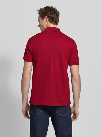 Męski model nosi Koszulkę polo z wyhaftowanym logo Model 'L.12.12 CORE' od LACOSTE, bawełna, krój regular fit, jednokolorowy, widok z tyłu.