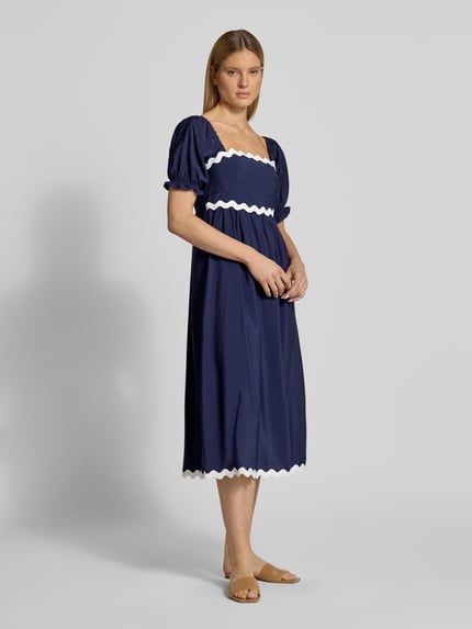 Frauenmodel trägt Tunikakleid mit Karree-Ausschnitt von Apricot, dunkelblau, A-Linie, Midikleid, 1/2-Arm, elastische Ärmelabschlüsse, Rückenlänge 120 cm, Brustweite 40 cm, Ärmellänge 30 cm, Ganzkörperansicht von vorne.