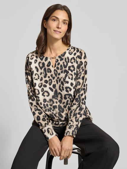 Vrouwenmodel draagt Blusenshirt in Leo-Optik met Schlüsselloch-Ausschnitt van monari in beige en zwart, regular fit, pure viscose, bovenlichaam close-up.
