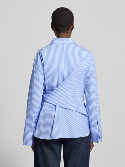 Frauenmodel trägt Regular Fit Bluse in Wickel-Optik Modell 'Rochelle' von Neo Noir, hellblau-weiß gestreifter Baumwoll-Mix, Rückenansicht.