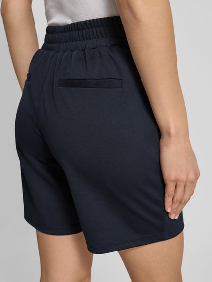 Vrouwenmodel draagt Shorts met elastische tailleband model 'Kate' van ICHI, regular fit, materiaal-mix met viscose, detailopname rugaanzicht.