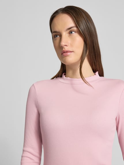 Frauenmodel trägt Slim Fit Langarmshirt aus Baumwoll-Mix von Tom Tailor Denim in Rosa, fein gerippt, hoher Ausschnitt, Nahaufnahme Oberkörper.