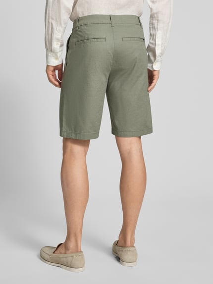 Męski model nosi Regular Fit Bermuda aus Leinen-Baumwolle-Mix od Tom Tailor Denim, jednolity kolor, widok całej sylwetki z tyłu.
