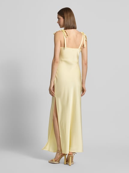 Frauenmodel trägt Slim Fit Midikleid aus Satin Modell 'Maxima' von LeGer by Lena Gercke in Hellgelb mit Zierschleifen und Ärmelloses-Design, seidige Satin-Optik, Rückenlänge 123 cm, Brustweite 34 cm, Ganzkörperansicht Rückansicht.
