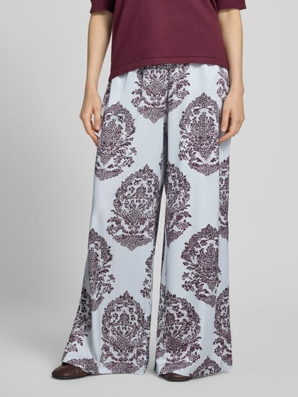 Frauenmodel trägt Wide Leg Pants mit Eingrifftaschen Modell 'Lunet' von Neo Noir, weites Bein, elastischer Bund, Nahaufnahme Unterkörper.