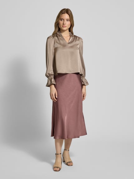 Frauenmodel trägt Relaxed Fit Bluse mit Tunika-Kragen Modell 'Amara' von Neo Noir, Elastischer-Material-Mix, Rüschenbesatz, Langärmelig, unifarben, Ganzkörperansicht von vorne.