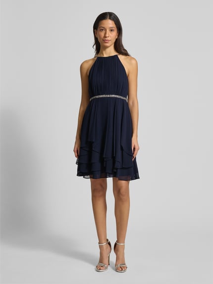 Frauenmodel trägt Cocktailkleid mit Nahtreißverschluss von Jake*s Cocktail, Dunkelblau, taillierter Schnitt, Rundhalsausschnitt, blickdichtes Unterkleid, Rückenlänge 92 cm, Brustweite 33 cm, Ganzkörperansicht von vorne.