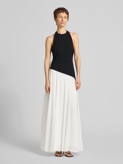 Modelka kobieca ma na sobie Cocktailkleid in Two-Tone-Machart Modell 'Elise' od Forever New, czarny top, biała zwiewna spódnica, szyfon, krój taliowany, maxikleid, długość tyłu w rozmiarze 36: 144 cm, szerokość w rozmiarze 36: 37 cm, widok całej sylwetki z przodu