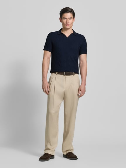 Męski model nosi Regular Fit Strick-Poloshirt Modell 'TONO' od CINQUE, bawełniany miks, strukturalny wzór, V-dekolt, długość tyłu w rozmiarze M: 67 cm, krój regular fit, widok całej sylwetki z przodu