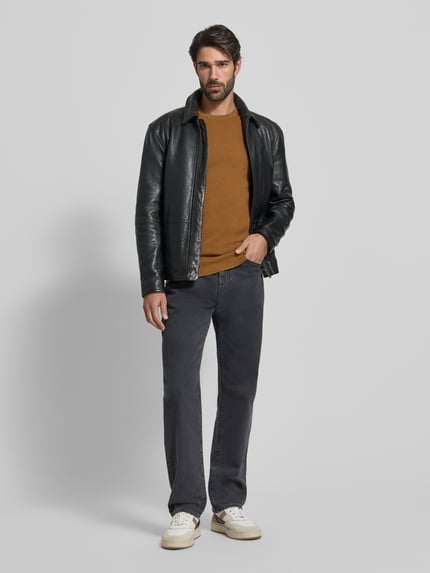 Männermodel trägt Regular Fit Strickpullover aus reiner Baumwolle von Tommy Hilfiger, unifarben, Strukturmuster, Ganzkörperansicht von vorne.