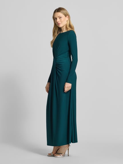 Frauenmodel trägt Abendkleid mit Rundhalsausschnitt von Forever New in Dunkelgrün mit Drapierung und Raffungen, Maxilänge, Ganzkörperansicht von vorne.