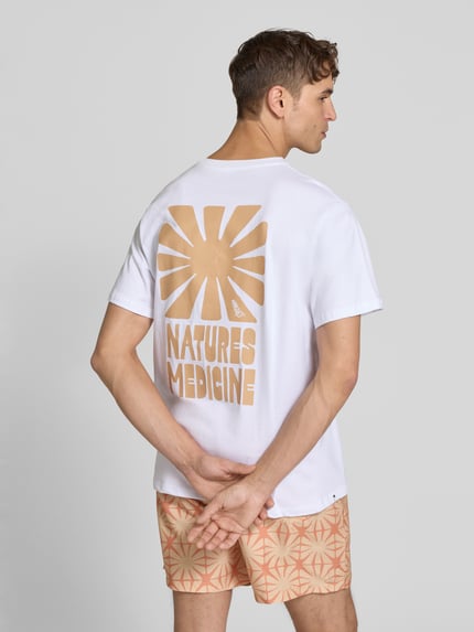 Männermodel trägt T-Shirt mit Label-Print und Rundhalsausschnitt von BOARDIES, witte katoen, regular fit, rugprint, ruglengte 73 cm, Ganzkörperansicht Rückansicht.