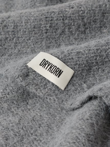 Produktfoto, Dreieckstuch mit Woll-Anteil von DRYKORN, graue Strick-Optik, Label-Patch, eingefasste Abschlüsse, Material-Mix, Detailansicht