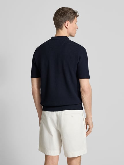 Männermodel trägt Regular Fit Poloshirt in Strick-Optik von Fynch-Hatton in Dunkelblau, Baumwoll-Mix, Polokragen, Rückenlänge 67 cm, Ganzkörperansicht Rückansicht.