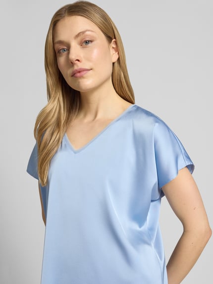 Frauenmodel trägt Blusenshirt aus Satin mit V-Ausschnitt von V by Vera Mont in Hellblau, Regular Fit, Kappärmel, Nahaufnahme Oberkörper.