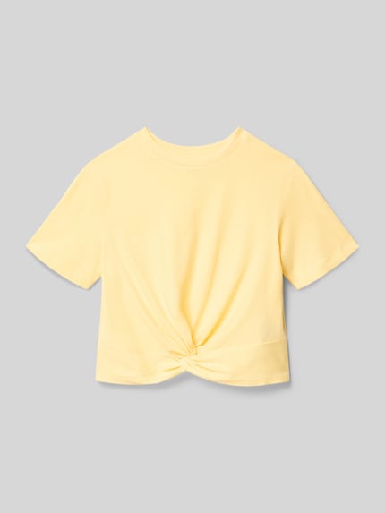 Produktfoto, Boxy Fit T-Shirt aus reiner Baumwolle Modell 'REX' von Only, Kinder T-Shirt, Optik: Unifarben, Knoten-Detail, Rundhals, Kurzarm, weiche glatte Textur, gelbe Farbe.