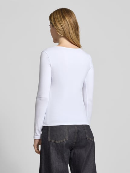 Frauenmodel trägt Longsleeve mit geripptem Rundhalsausschnitt von ZABAIONE, weiß, Baumwoll-Elasthan-Mix, Ganzkörperansicht Rückansicht.