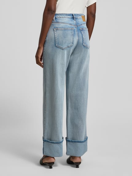 Frauenmodel trägt Wide Leg Jeans mit fixiertem Aufschlag Modell 'Dikan' von My Essential Wardrobe, hellblauer Baumwoll-Mix, 5-Pocket-Design, ausgestellter Schnitt, Saum detailreich strukturiert, Ganzkörperansicht Rückansicht.