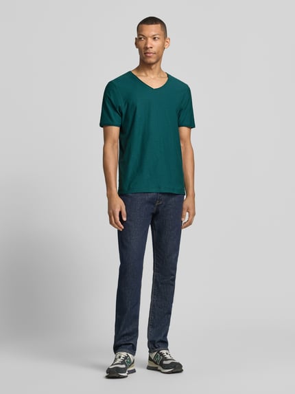 Męski model nosi Regular Fit T-Shirt mit V-Ausschnitt von MCNEAL, ciemnozielony, bawełna, krój regular fit, całkowity widok z przodu.