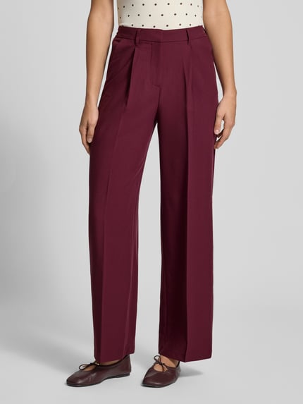 Frauenmodel trägt Hose mit Bügelfalten Modell 'AYA ELLIS' von JJXX, weinrot, Wide Fit, Material-Mix mit Viskose, Nahaufnahme Oberkörper.