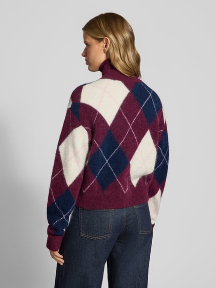 Frauenmodel trägt Regular Fit Pullover aus Alpaka-Woll-Mix von Tommy Jeans in Weiß, Dunkelblau und Bordeaux, Rautenmuster, Ganzkörperansicht Rückansicht, Damen Pullover von Tommy Jeans.