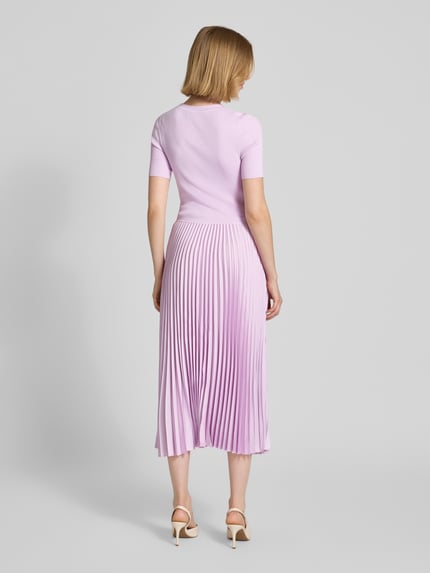 Vrouwenmodel draagt Tailliertes Businesskleid aus Viskose-Mix Modell 'FADRIDI' van BOSS, look: effen, getailleerd, midilengte, ronde hals, plissévouwen, korte mouw, rechte zoom, geheel in lila tinten, textuur: glad bovenstuk, plissérok, rugaanzicht totaalbeeld