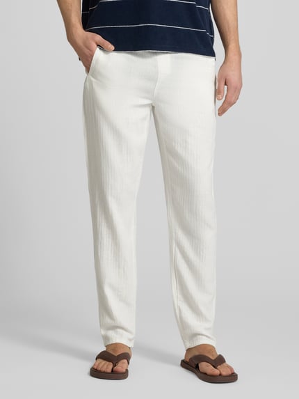 Männermodel trägt Hose aus Leinen-Baumwoll-Mix Modell 'MARCO' von Blend, weiß, Regular-Fit, strukturierte Optik, Ganzkörperansicht von vorne. Bundweite 42 cm, Innenbeinlänge 80 cm, elastischer Bund.