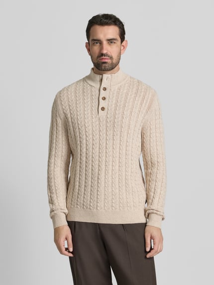 Männermodel trägt Strickpullover mit gerippten Abschlüssen von Fynch-Hatton, Baumwoll-Woll-Mix, Regular-Fit, Stehkragen, Knopfleiste, Beige, Ganzkörperansicht von vorne.