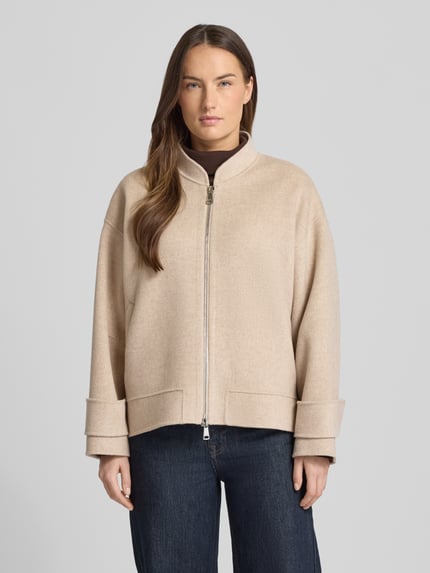 Frauenmodel trägt Regular Fit Jacke aus reiner Schurwolle von Windsor in Beige mit Stehkragen und Zweiwege-Reißverschluss, Ganzkörperansicht von vorne.