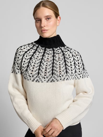 Modelka prezentuje Strickpullover aus Wolle mit Stehkragen von Closed, czarno-biały, gruby splot, krój straight fit, widok z przodu, długość tyłu 56 cm, długość rękawa 67 cm, czyste wykończenie rękawów, rękawy i dół gładkie, ramiona i stójka wzorzyste