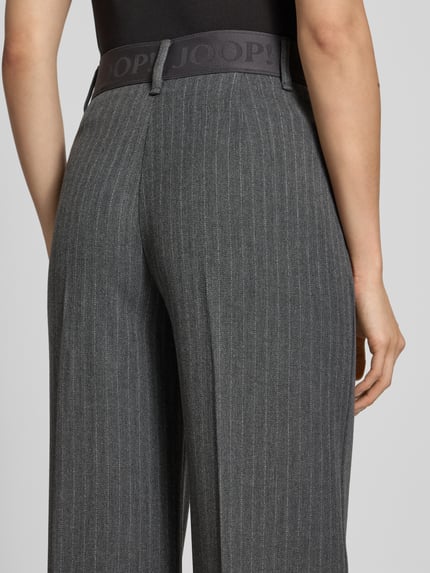 Vrouwenmodel draagt grijze pantalon met fijne krijtstrepen, brede elastische tailleband, Anzughose mit Viskose-Anteil model 'Peeky2' van JOOP!, detailopname rugaanzicht