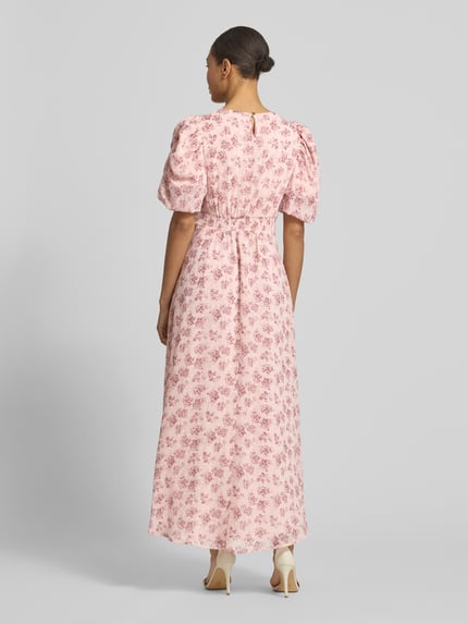 Vrouwenmodel draagt roze maxi-jurk uit chiffon met pofmouwen, all-over look, model 'A-Linie' van Neo Noir, model 'Kikka', rugaanzicht.
